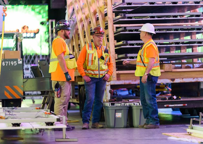 Workers chat near a semi load of panels to be installed on the Fremont Street Experience digital canopy.